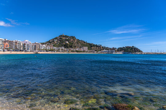 Panorama view of Blanes cityscape, the mountain Sant Joan with the castle and Santa Anna tip with El Convent monastery in summer on sunny day, Selva, Girona Catalonia, Spain