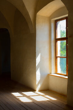 Abandoned stone interior with sunlight through window creating natural light and shadow in empty architectural space