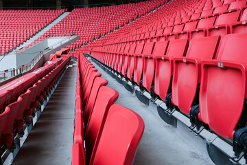 Stadium interior with red seating and green pitch view © 向 陈
