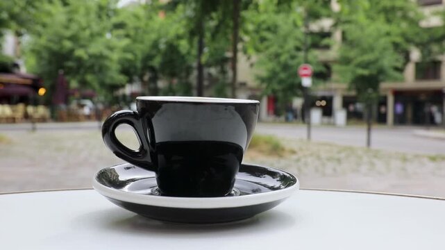 Cup of fresh hot coffee on the table of an outdoor cafe in Paris, France.