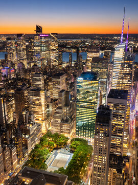 Elevated twilight view of Midtown Manhattan skyscrapers and Bryant Park. Illuminated New York City skyline with Hudson Yards and view of Hudson River, USA