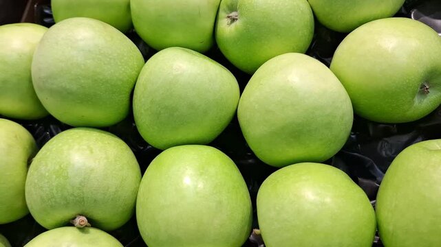 Fresh ripe green Granny Smith apples close up, organic sour fruits, healthy food ingredients and grocery store agricultural retail concept. Healthy snacks and desserts. Food for vegans and vegetarians