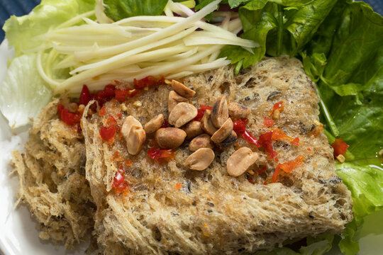 Appetizing Close-Up of Thai-Style Crispy Catfish Salad (Yam Pla Duk Foo) with Golden Crispy Catfish Flakes and Spicy Sweet Dressing
