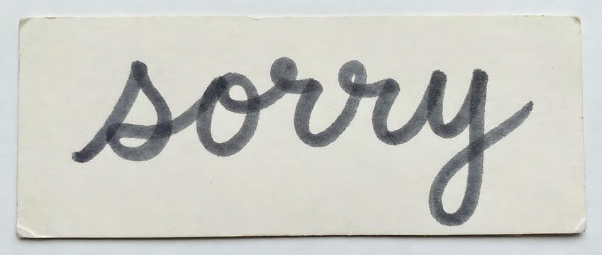 Handwritten sorry message on aged cream paper with blue ink script lettering