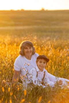 Sweet preteen child, boy, playing in a field on sunset with kite and old vingate car, walking with grandmother in the countryside