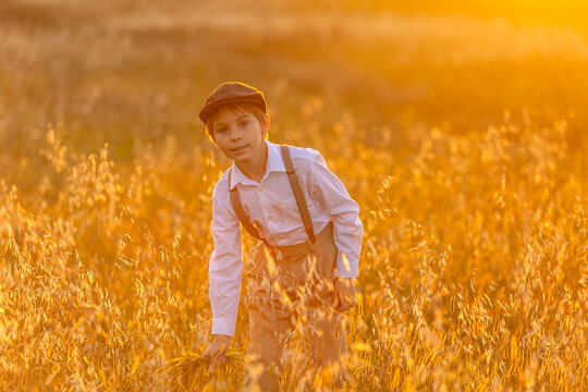 Sweet preteen child, boy, playing in a field on sunset with kite and old vingate car, walking with grandmother in the countryside