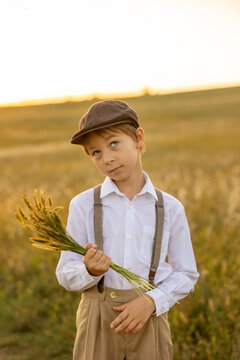 Sweet preteen child, boy, playing in a field on sunset with kite and old vingate car, walking with grandmother in the countryside
