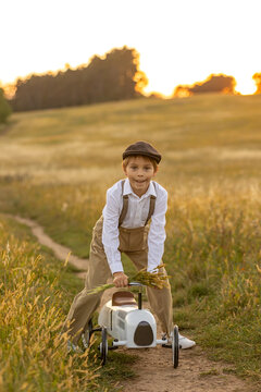 Sweet preteen child, boy, playing in a field on sunset with kite and old vingate car, walking with grandmother in the countryside