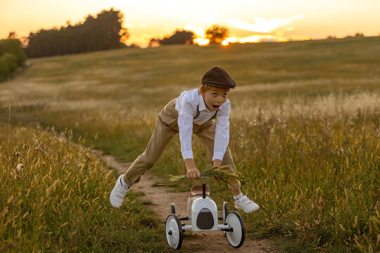 Sweet preteen child, boy, playing in a field on sunset with kite and old vingate car, walking with grandmother in the countryside
