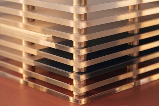 Close-Up of a Modern Multi-Tiered Acrylic Structure with Sleek Metallic Cylindrical Spacers