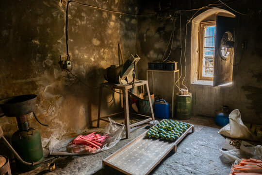 Colorful bars of handmade soap dry inside an old workshop lit by a single window, North Governorate, Tripoli, Lebanon