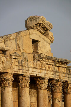 Carved stone pediments and column capitals crown the ruins of an ancient Roman temple against a clear sky, Baalbek-Hermel Governorate, Baalbek, Lebanon