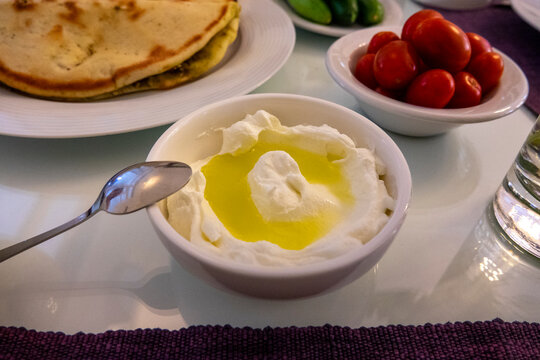 A traditional Lebanese breakfast spread features labneh drizzled with olive oil alongside fresh tomatoes and manoushe bread, Beirut Governorate, Beirut, Lebanon
