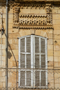 A weathered wooden shutter sits beneath an intricately carved stone frieze with star patterns, Beqaa Governorate, Zahle, Lebanon