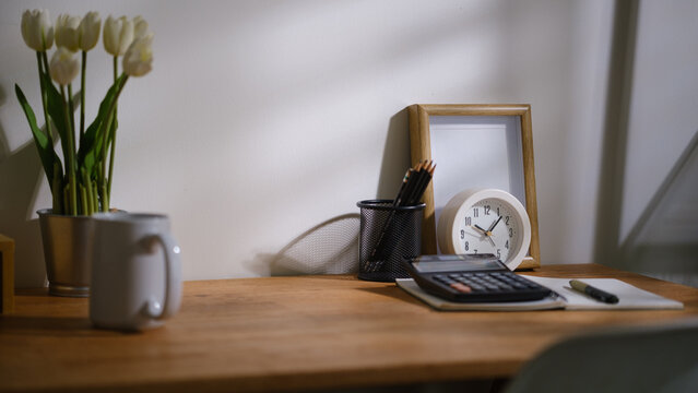 Financial documents calculator and office supplies arranged on a wooden desk.