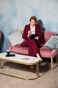 Executive seated on soft sofa studying reports and charts attentively