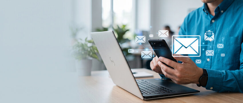 Business professional using a smartphone and laptop with floating email icons, representing digital communication, online messaging, email management and business correspondence.