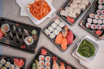 Assorted Japanese sushi delivery set with nigiri, maki rolls, chuka wakame, and spicy carrot salad, top-down flatlay © Curtis.at 