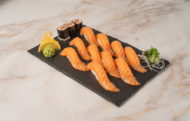 Classic salmon nigiri set with salmon maki rolls served on a black slate platter, top-down view © Curtis.at 