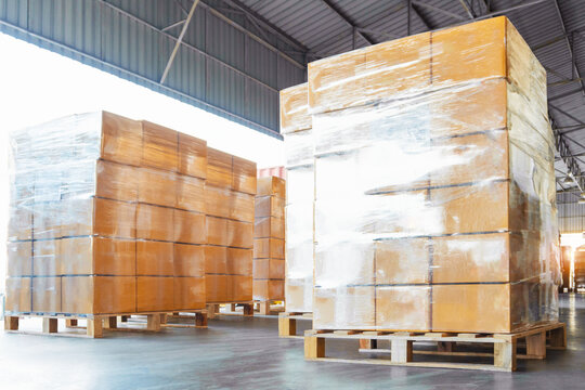 Bulk of Package Boxes Wrapped Plastic on Pallets. Truck Loading Dock Warehouse. Cardboard Boxes, Supply Chain, Supplies Goods Shipment. Distribution Warehouse Logistics	
