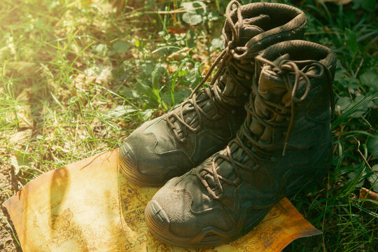 Hiking boots on a map in the forest.