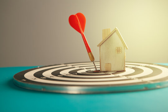 House on dartboard with red dart arrow, business and finance concept