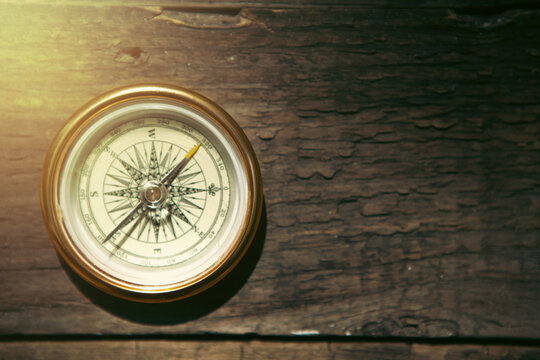 Compass on wooden background, vintage color tone