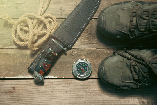 Compass, boots and rope on a wooden background. Toned.