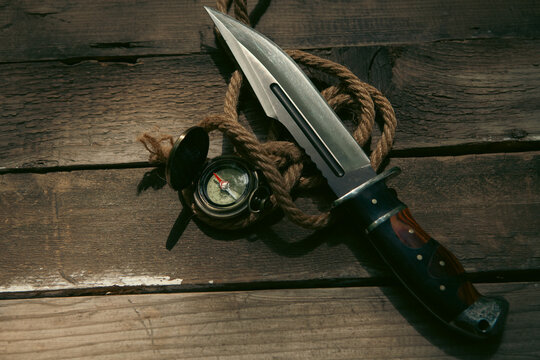 Compass and rope on a wooden background.