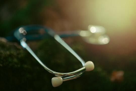 Stethoscope on moss background with sunlight. Medical and healthcare concept.