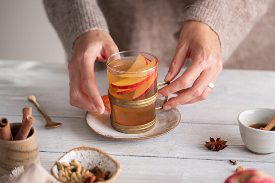 Hands holding autumn hot apple cider, cozy lifestyle drink