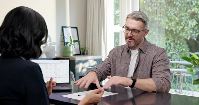 Meeting, broker or man in home office with paper, rental form or review of mortgage contract. Talking, mature client or realtor with document, investment planning or loan application in consultation.