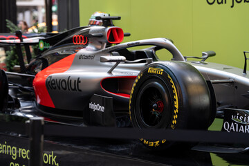 Obraz premium NEW YORK, USA – SEPTEMBER 16, 2026: a Formula 1 race car display in Times Square with sponsor branding and a close view of the front wheel and cockpit.