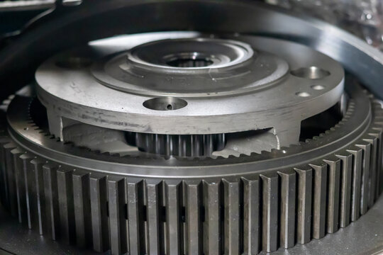 Planetary gear assembly with internal ring gear rests on table in transmission repair workshop.