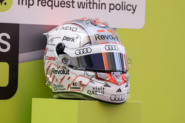Fototapeta premium NEW YORK, USA – SEPTEMBER 16, 2026: a Formula 1 racing helmet on display with sponsor logos against a bright branded backdrop.