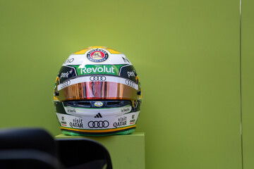 Fototapeta premium NEW YORK, USA – SEPTEMBER 16, 2026: a Formula One racing helmet with sponsor logos displayed against a plain green background.