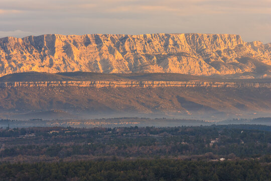 Sainte-Victoire Mountain illuminated by warm sunrise light in Provence, France.