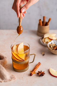 Honey dipper over apple cider, autumn drink preparation close-up