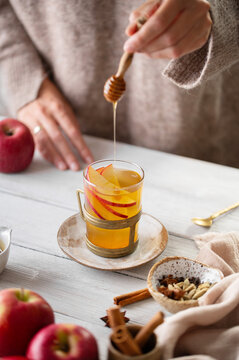 Warm spiced apple drink sweetened with honey by hand