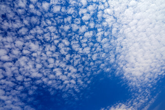 blue sky with delicate white cloud ripples and a clear open patch at bottom