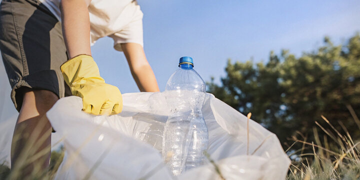 Taking care of environment by separating plastic waste for recycling with people who are putting plastic bottles into bags