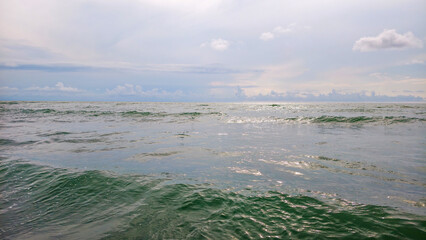 Ocean waves gently rolling under a cloudy sky, creating a peaceful scene representing vastness, environmental themes, and a sense of calm for various commercial applications © Newleks