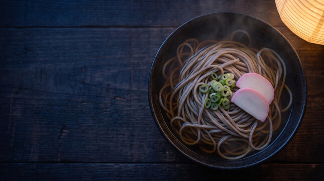 Overhead view of hot soba noodles with fish cake at night
