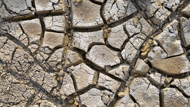 Arid cracked earth displaying extreme drought conditions and climate change impact, presenting desertification issues and environmental degradation