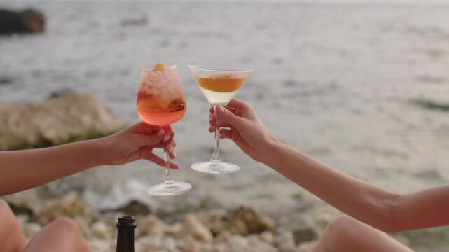 Friends enjoy cocktails by the beach at sunset while sharing happy moments