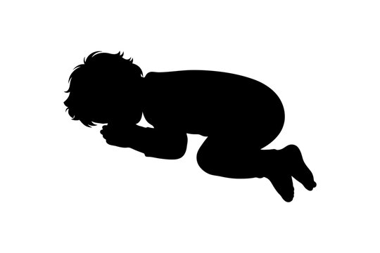 Silhouette of caucasian young child kneeling and praying.