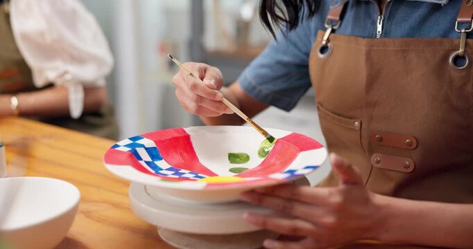 Hands, woman and painting in class with pottery, sculpture and custom design of handmade craft. Female person, paint brush or decorating in studio with ceramic bowl, artistic process and diy creation