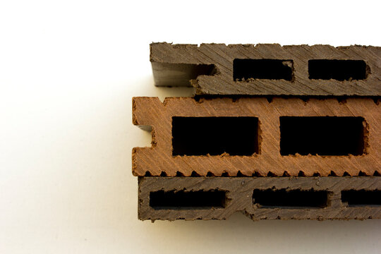 Top view of composite wood decking board cross section profile samples on white background