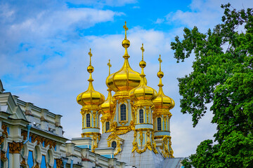 Golden Onion Domes of a Cathedral Against Blue Sky and Trees © EVGENII