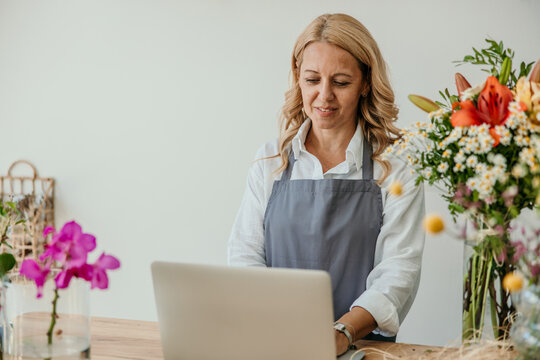 Florist woman managing online orders with laptop